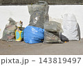 Various garbage bags and construction waste sacks lined up against a wall 143819497