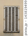 Vintage wooden window shutters with peeling paint on a beige wall 143819499