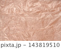 A full frame texture shot of a crumpled pink plastic film background 143819510