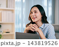 Pregnant remote worker smiles at her laptop at home 143819526