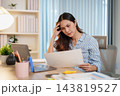 Remote worker reviews paperwork while working from home 143819527