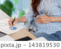 Pregnant remote worker reviews a chart at home 143819530