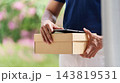 Parcel delivery worker holds a box with a tablet 143819531