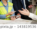 Construction project team discusses building plans 143819536