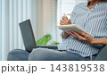 Remote work at home as a worker writes in her notebook 143819538