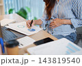 Pregnant remote worker marks a chart at home 143819540