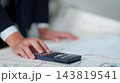 Business worker calculating figures over paperwork 143819541