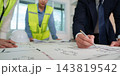Construction project team annotates building plans 143819542
