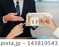 Construction team reviews an architectural building model 143819543