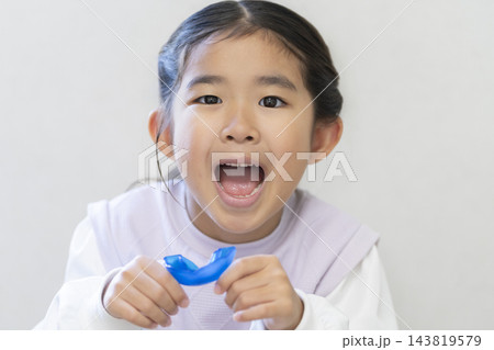 矯正用マウスピースを持った6歳の女の子 矯正用マウスピースを持った6歳の女の子 143819579