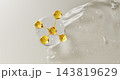 Clear serum drop with gold oil molecule and collagen peptide jelly gel texture on white 3d background. Transparent liquid cosmetic wavy surface with bubbles, beauty skincare product. 3D illustration Clear serum drop with gold oil molecule and collagen peptide jelly gel texture on white 3d background. Transparent liquid cosmetic wavy surface with bubbles, beauty skincare product. 3D illustration 143819629