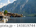 Hallstatt, Austria Alpine Village on Lake Shore with Mountains and Church Spire in Sunny Daytime Landscape 143819744