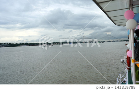 View of Vidyasagar Setu bridge and river vessels on Hooghly river from a decorated cruise boat in Kolkata View of Vidyasagar Setu bridge and river vessels on Hooghly river from a decorated cruise boat in Kolkata 143819789