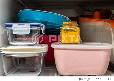 Glass and plastic food storage containers stacked on kitchen Glass and plastic food storage containers stacked on kitchen 143820041