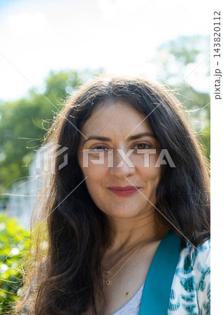 Close up headshot of beautiful middle aged brunette woman looking at camera Close up headshot of beautiful middle aged brunette woman looking at camera 143820112