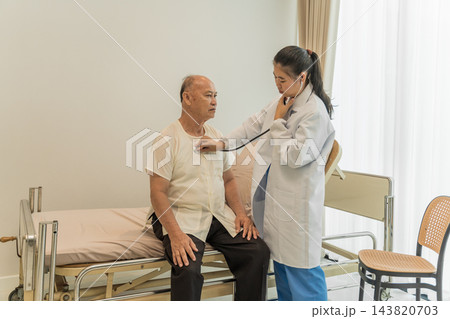 Female doctor explaining treatment options to elderly man in clinic. 143820703
