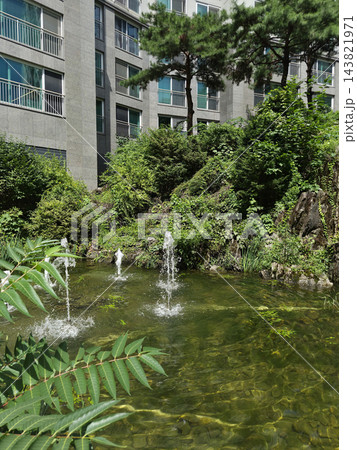 This is a garden with a pond within a Korean apartment complex.	 143821971