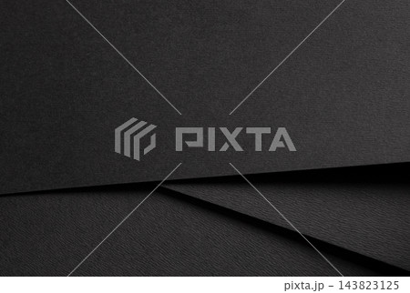 Black paper texture, layered sheets with diagonal lines and folded edges. Dark background close up, matte surface with fold and shadow. Minimalistic abstract material. Black paper texture, layered sheets with diagonal lines and folded edges. Dark background close up, matte surface with fold and shadow. Minimalistic abstract material. 143823125