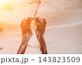 Woman jacket desert posing in a white rocky canyon during golden hour with warm sunset lens flare 143823509