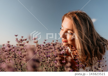 Lavender field woman smelling fragrant purple flowers in a blooming meadow during sunset with clear blue sky copy space Lavender field woman smelling fragrant purple flowers in a blooming meadow during sunset with clear blue sky copy space 143823521