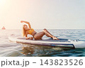Woman Paddleboard Ocean: Young woman relaxes on a paddleboard in the ocean. 143823526