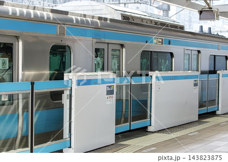 鉄道イメージ、京浜東北線のホームドアの前で列車を待つビジネスマン 143823875
