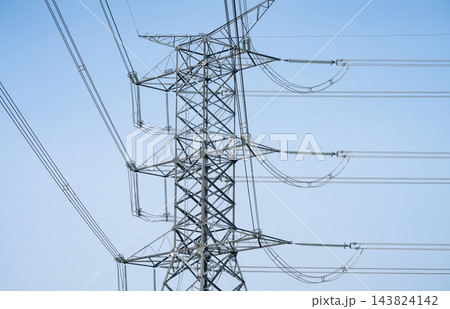 High voltage electricity transmission tower and overhead power lines against clear blue sky, showing modern electrical grid infrastructure delivering reliable energy for cities and industry High voltage electricity transmission tower and overhead power lines against clear blue sky, showing modern electrical grid infrastructure delivering reliable energy for cities and industry 143824142