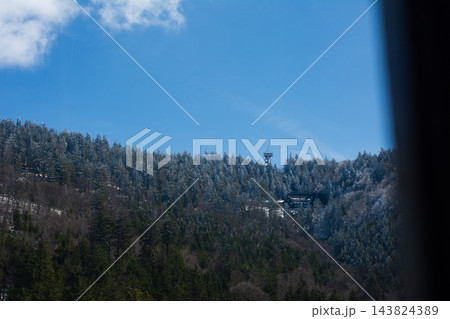 Snow-covered hills with a radio tower against a bright blue sky on a sunny day, showcasing the beauty of nature and tranquility in radio communication locations 143824389