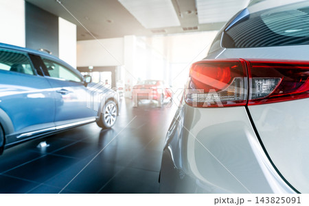 Rear taillight of a new silver car displayed in a modern luxury automobile showroom. Dealership inventory for vehicle purchase, financing, leasing, rental and insurance. Modern dealership business. Rear taillight of a new silver car displayed in a modern luxury automobile showroom. Dealership inventory for vehicle purchase, financing, leasing, rental and insurance. Modern dealership business. 143825091