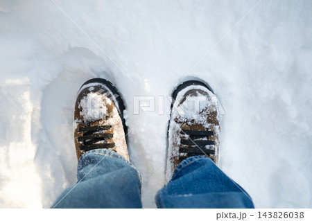 Winter boots standing in deep fresh snow top view Winter boots standing in deep fresh snow top view 143826038
