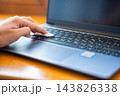 Hand pressing cleaning gel onto laptop keyboard to remove dust and debris. Keyboard cleaning compound collects dirt and particles between computer keys 143826338
