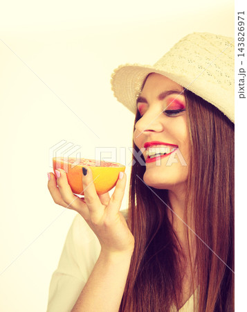 Woman holding half of grapefruit citrus fruit in hand 143826971