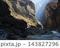 虎跳峡の切り立つ岩壁に挟まれた川と巨岩 143827296