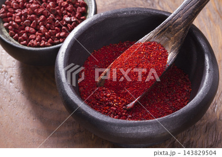 achiote in bowl on wooden background, achiote paste achiote in bowl on wooden background, achiote paste 143829504