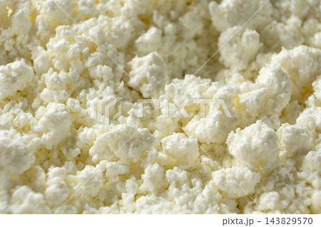 Crumbly white curd cheese background with copy space Crumbly white curd cheese background with copy space 143829570