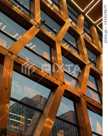 Modern timber framed building facade with reflective windows and geometric architectural structure 143829677