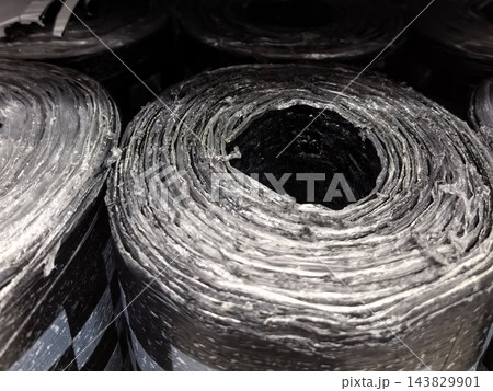 Close-up view of black material rolls stacked in storage area 143829901