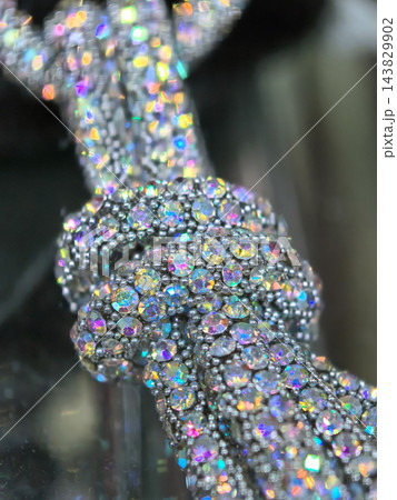 Shimmering crystal knot showcasing vibrant reflections and intricate design Shimmering crystal knot showcasing vibrant reflections and intricate design 143829902