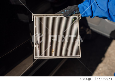 A mechanic is changing the cabin air filter. A mechanic is changing the cabin air filter. 143829974