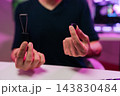 Cropped shot of person hands holding black keycap puller and single keyboard key, demonstrating process of computer keyboard repair and customization on desk with blurred background. 143830484
