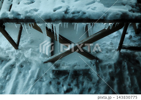 Snow-covered table with hanging icicles Snow-covered table with hanging icicles 143830775