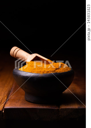 Turmeric Powder in a Wooden Spoon and Bowl Turmeric Powder in a Wooden Spoon and Bowl 143831823