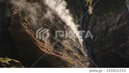 Ambrym Island's Benbow and Marum volcano crater rim showing a column of steam and gas rising from the deep caldera, highlighting the raw power and geological activity of the stratovolcano 143832243