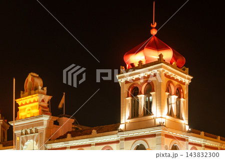 Low-angle view of the illuminated Moorish Revival red dome and tower of the historic Loule Municipal Market in Portugal at night Low-angle view of the illuminated Moorish Revival red dome and tower of the historic Loule Municipal Market in Portugal at night 143832300