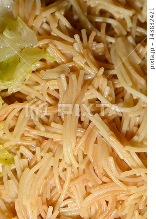 A detailed close-up photograph of a ramen noodle dish with overlapping long noodles in a creamy light yellow sauce 143832421