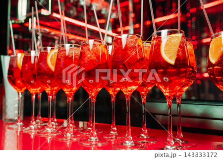 Red cocktails with ice and citrus slices in a stylish bar 143833172
