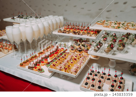 Elegant catering buffet with assorted gourmet canapes and champagne glasses Elegant catering buffet with assorted gourmet canapes and champagne glasses 143833359