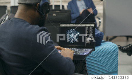 Artificial intelligence, laptop and traveler as man reviews neural network visualization on screen beside luggage. Machine learning, coding and digital research connect technology with airport travel. Artificial intelligence, laptop and traveler as man reviews neural network visualization on screen beside luggage. Machine learning, coding and digital research connect technology with airport travel. 143833386
