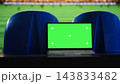 Green screen, laptop and football stadium as blank chroma key display stands between blue seats facing soccer pitch. Screen replacement, sports marketing and advertising support editable content. 143833482