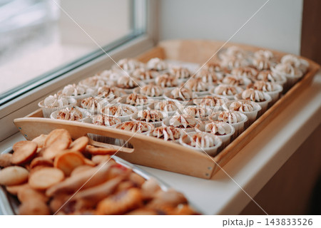 Assorted meringue pastries and cookies arranged on a wooden serving tray Assorted meringue pastries and cookies arranged on a wooden serving tray 143833526